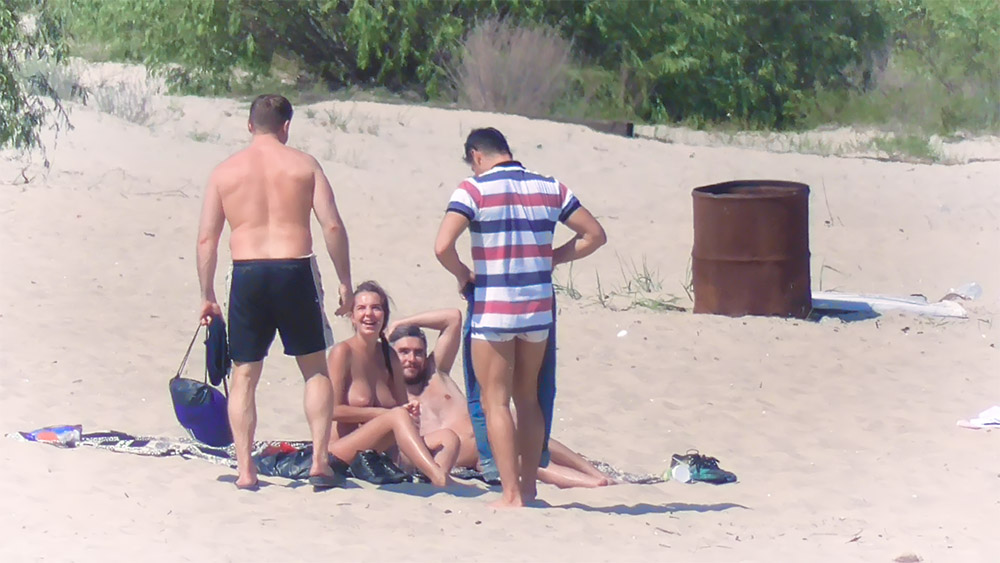 Samen zittend op een deken op een nudistenstrand