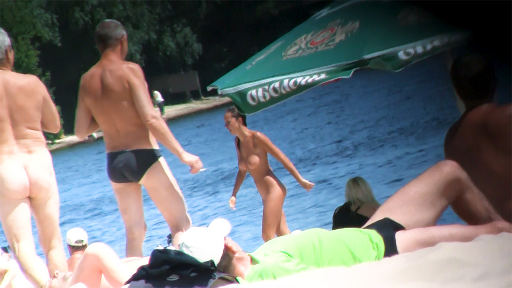 Walking the Shoreline Among Nude Beach Sunbathers