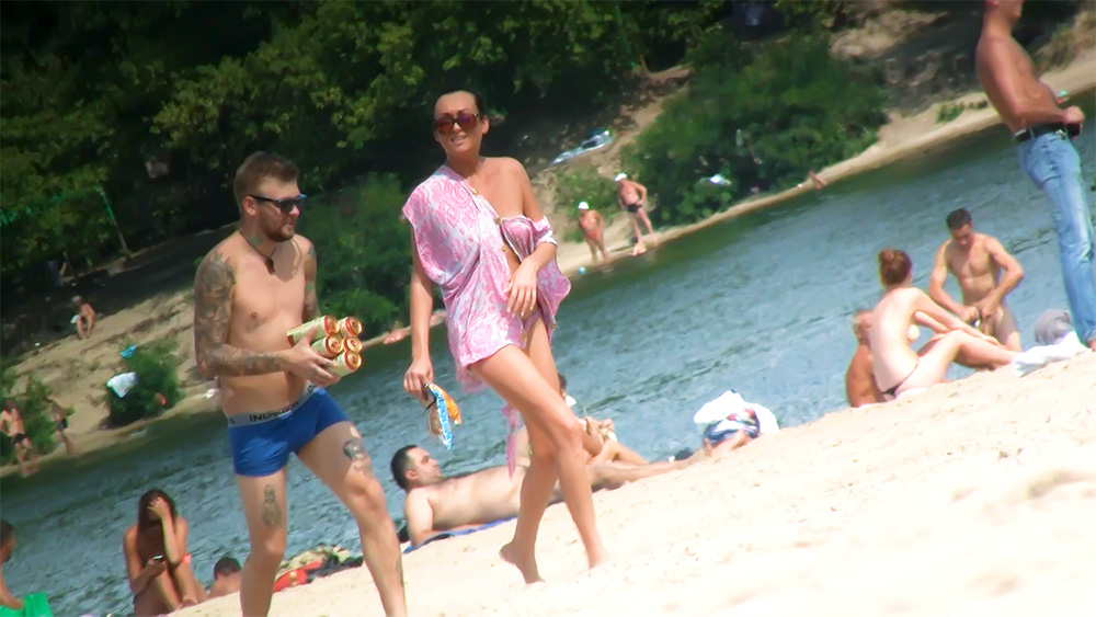 Walking Past Sunbathers on a Naturist Riverbank