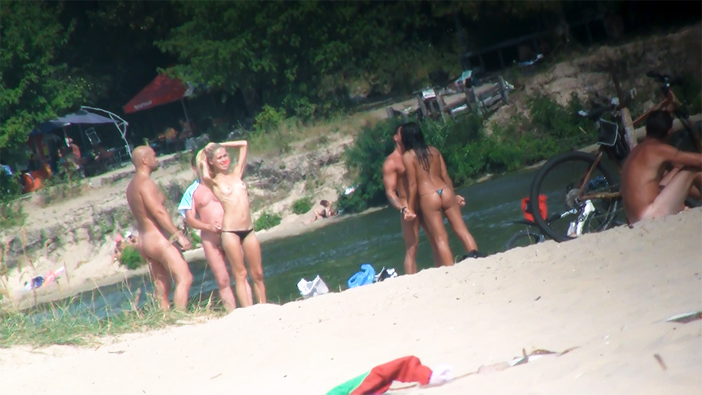 Cinco Naturistas Reunidos na Margem de uma Praia Fluvial
