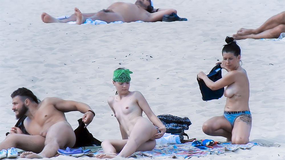 Dvě naturistky se usazují na vzorovaný plážový ručník