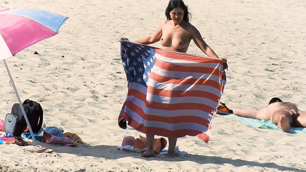 Holding an American Flag Towel on a Topless Beach