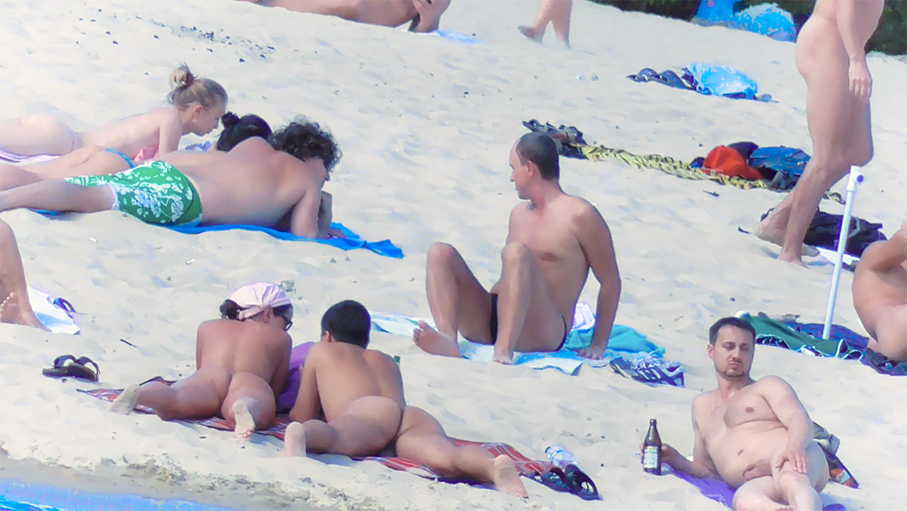 Twee naturisten rusten naast elkaar op de zandige kust