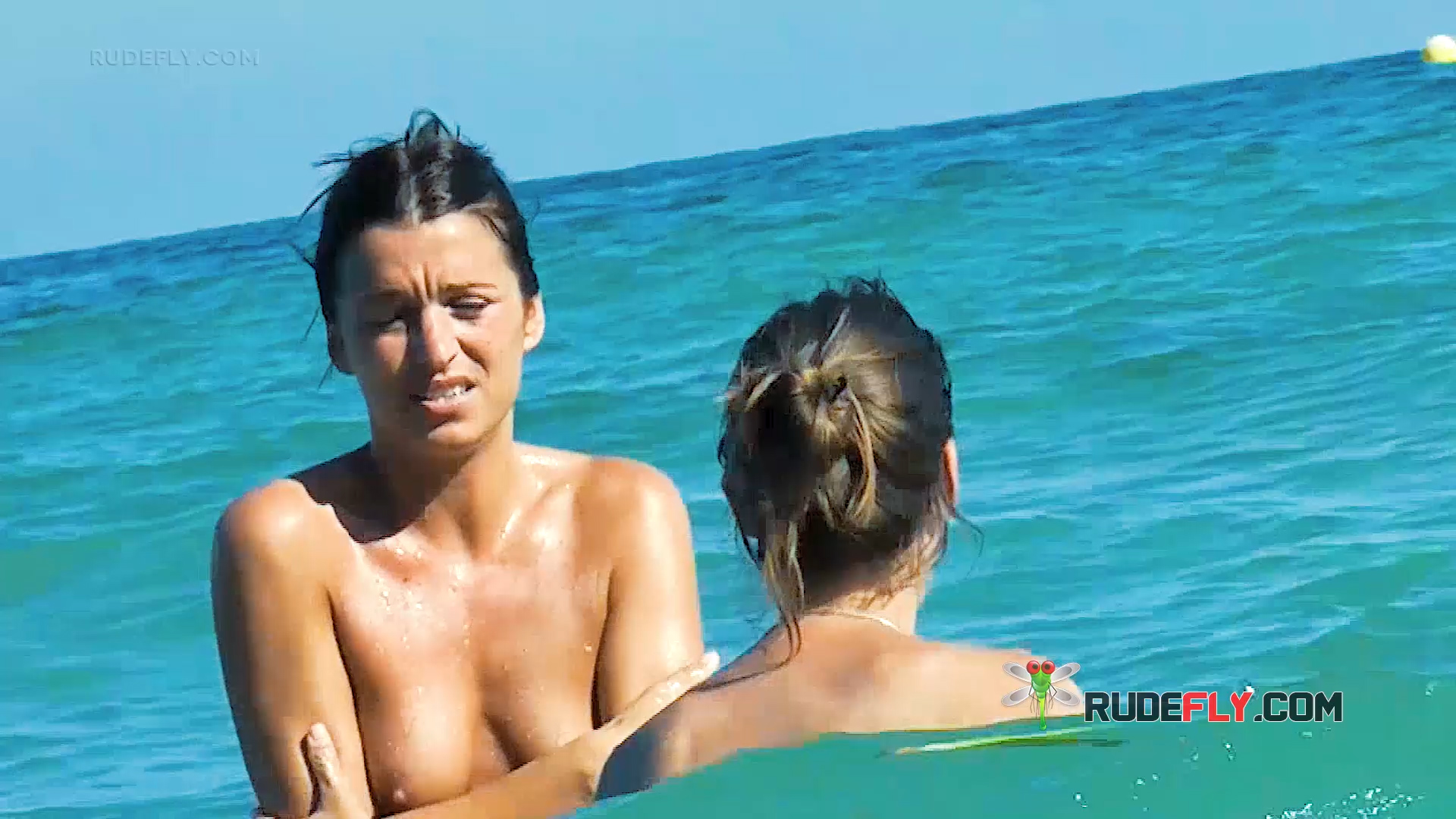 Due donne in topless nelle acque basse e turchesi