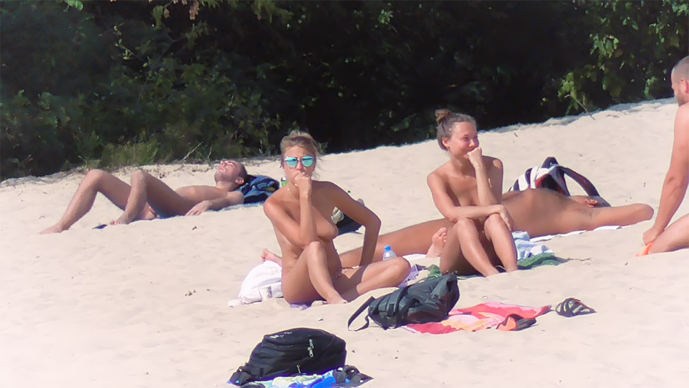 Hot nude beach girl is catching some rays while a camera perfectly films her from behind