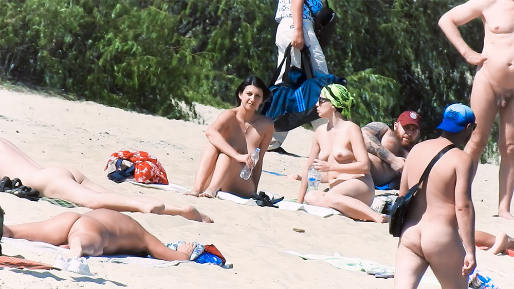 Family nudists set up camp at the beach and enjoy their day.