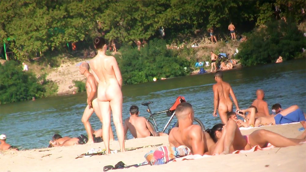 Standing by the Water Among Nudists on a Riverbank