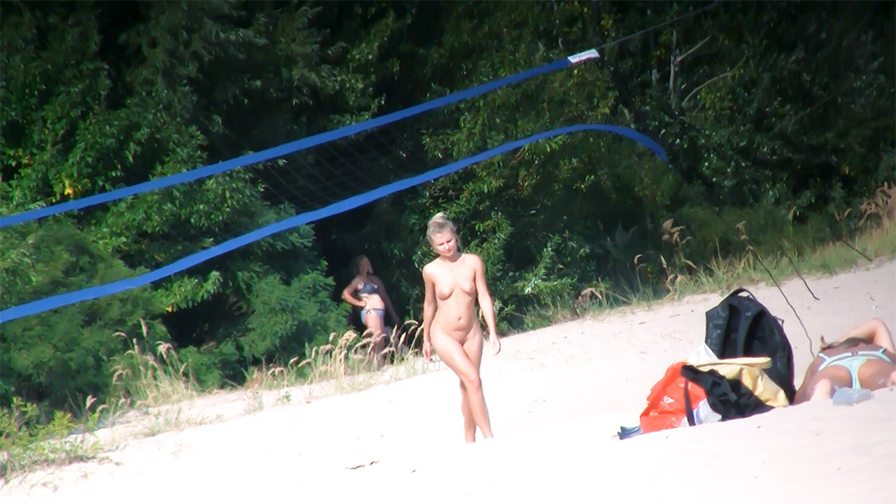 Busty family nudist is getting tanned on the sandy beach