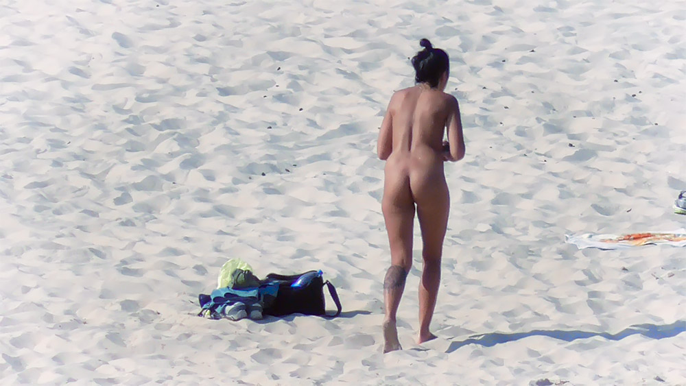 Moment na nudistické pláži vedle tašky se šnorchlem