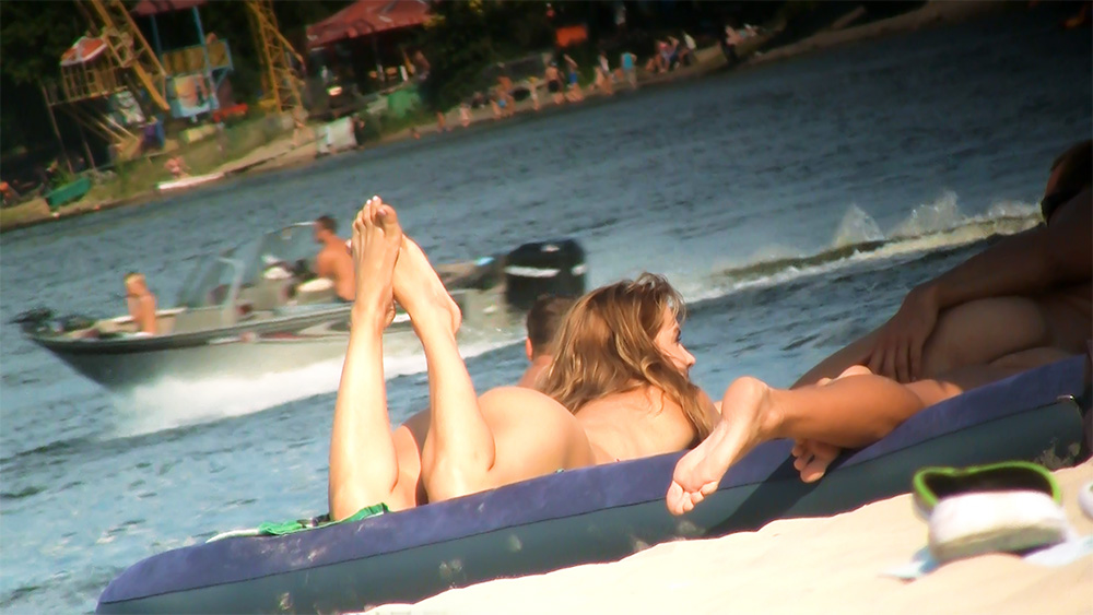 Two Naturists Drifting on an Inflatable Lake Raft