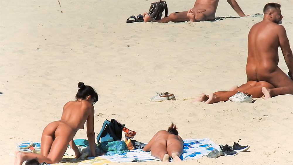Nude Beach Towel Setup Beside a Glass Bowl on the Sand