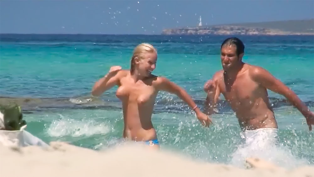 Splashing Through Shallow Surf on a Topless Beach