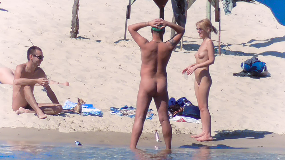 Two Nudists Chatting Beside the Shallow Water