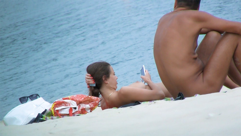 Stunning young nudist is relaxing on the beach