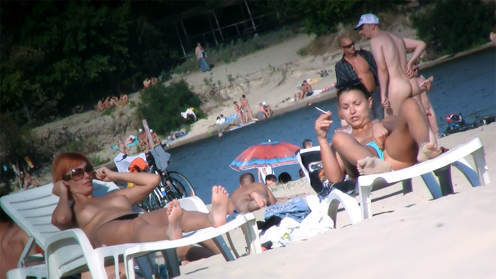 Rušné lehátko na topless pláži s přestávkou na cigaretu