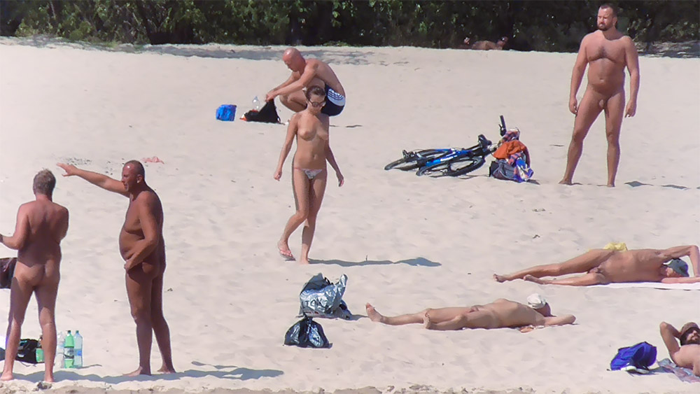 Sandy Beach with a Bicycle and a Topless Sunbather