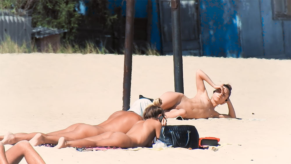 Here I am quietly posing for movies while being watched by a nude guy on the strand.