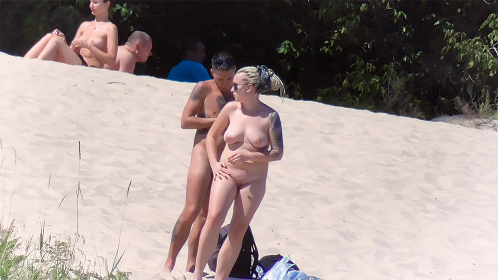 Nude Beach Couple Pausing Beside a Sandy Dune