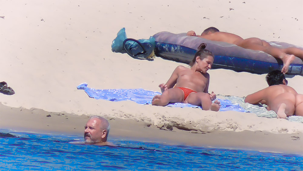 Topless Beach Towels Beside a Large Inflatable Mat
