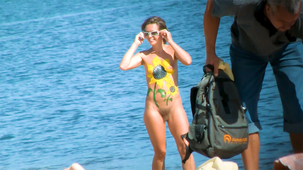 Sunflower Body Paint on a Sunlit Nudist Beach Shoreline