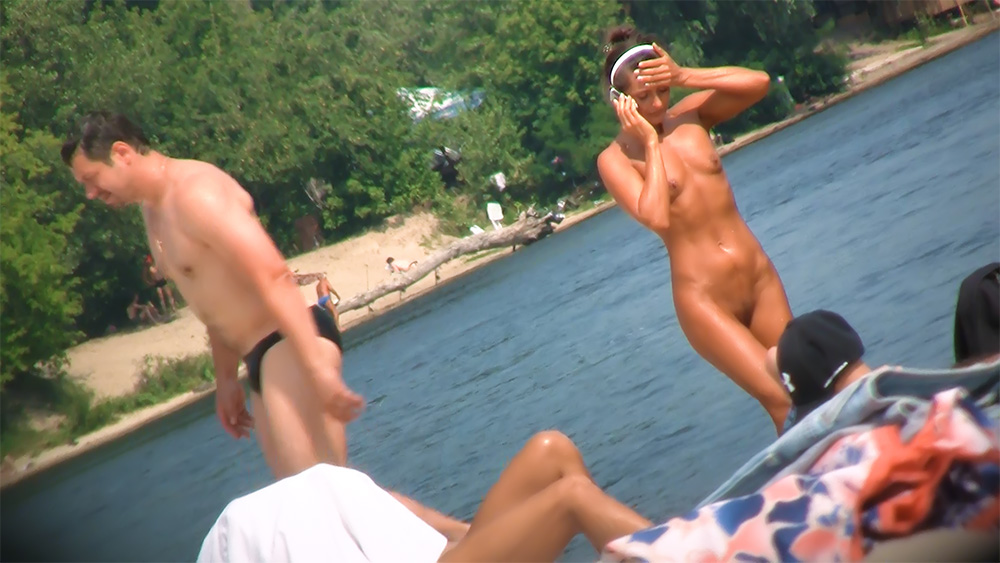 Poprawianie włosów na brzegu plaży nudystów