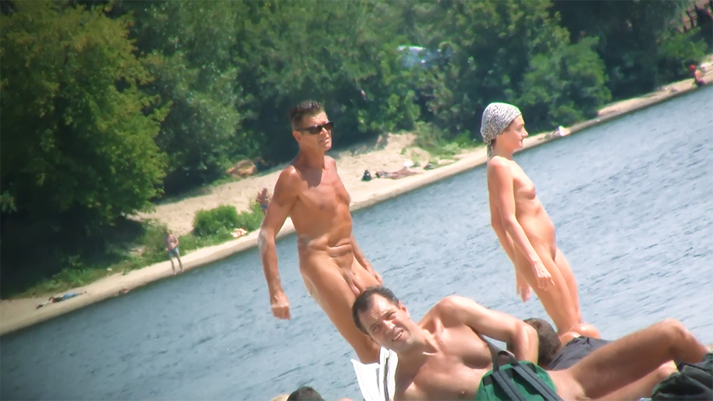 Stojící u kraje vody na nudistické pláži v koupací čepici