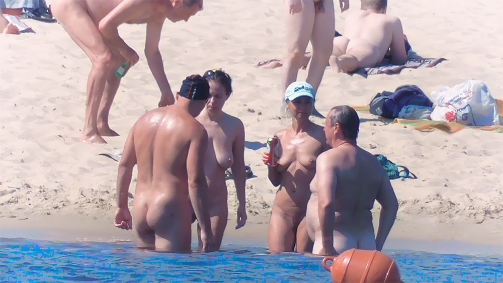 Pět koupajících se na nudistické pláži pohromadě u vody