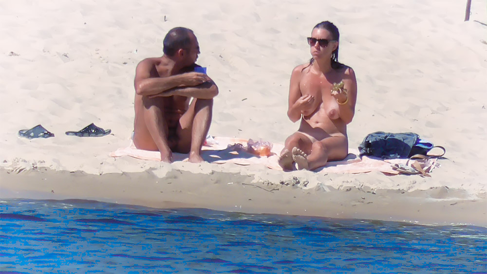 Two Nudists Sitting on Towels at a Nude Beach
