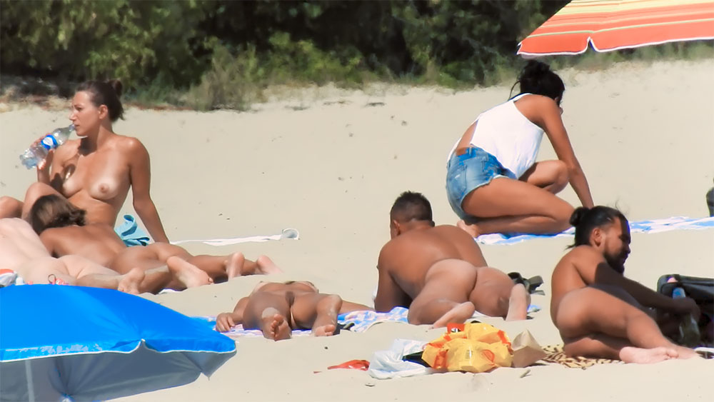 Two Nude Beach Sunbathers Resting on Striped Towels