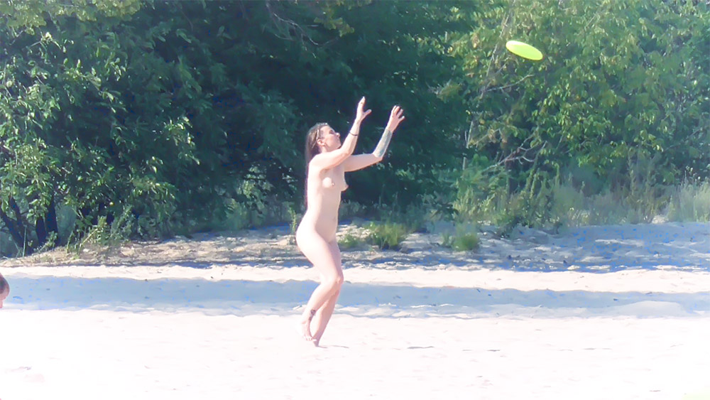Frisbeegooien op het naaktstrand bij de boomgrens