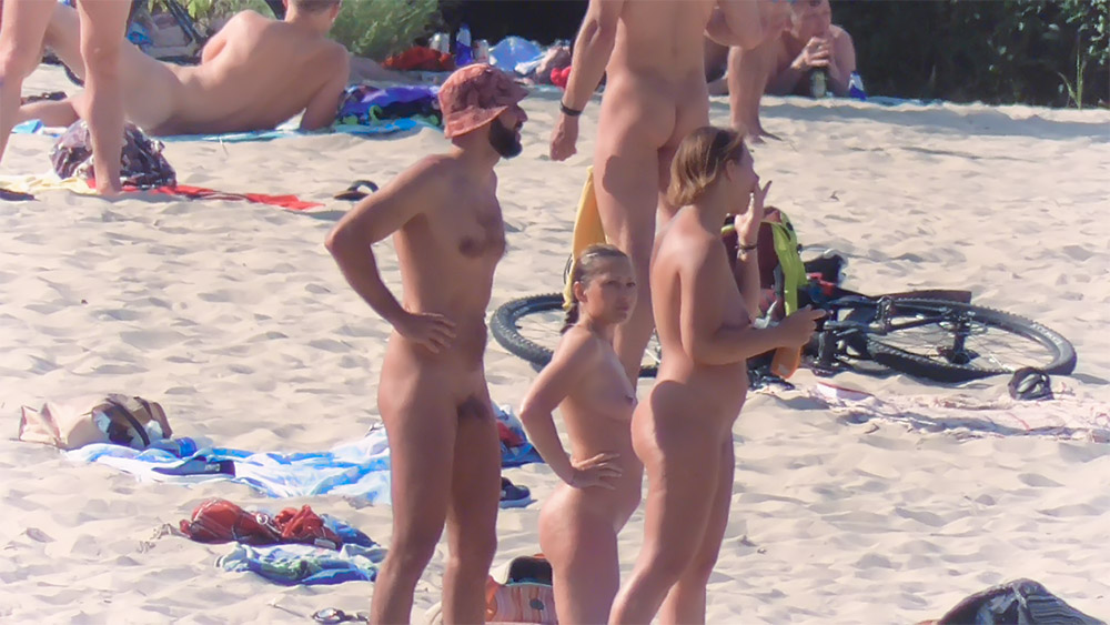 Vrouw met flinke boezem en opgestoken haar doet in haar eentje aan openbaar naturisme.