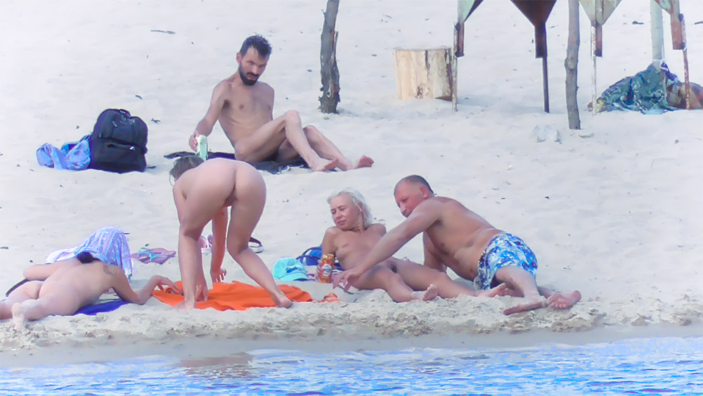 Five Nude Beach Visitors on an Orange Towel