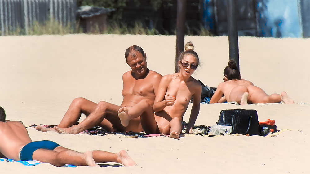 Drie nudisten rusten bij een donkere plunjezak
