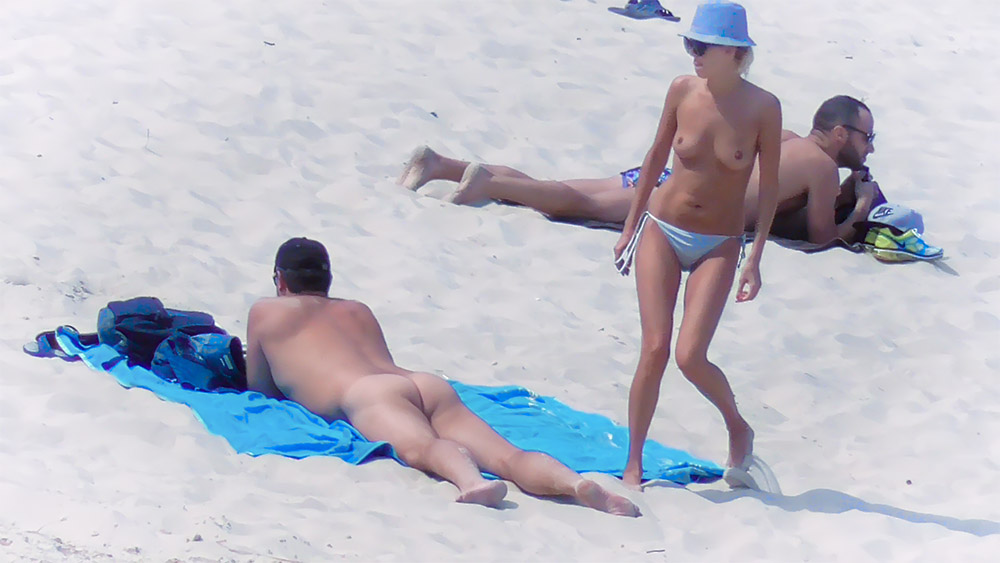 Topless Beach Moment Beside Sunbathers on Light Sand