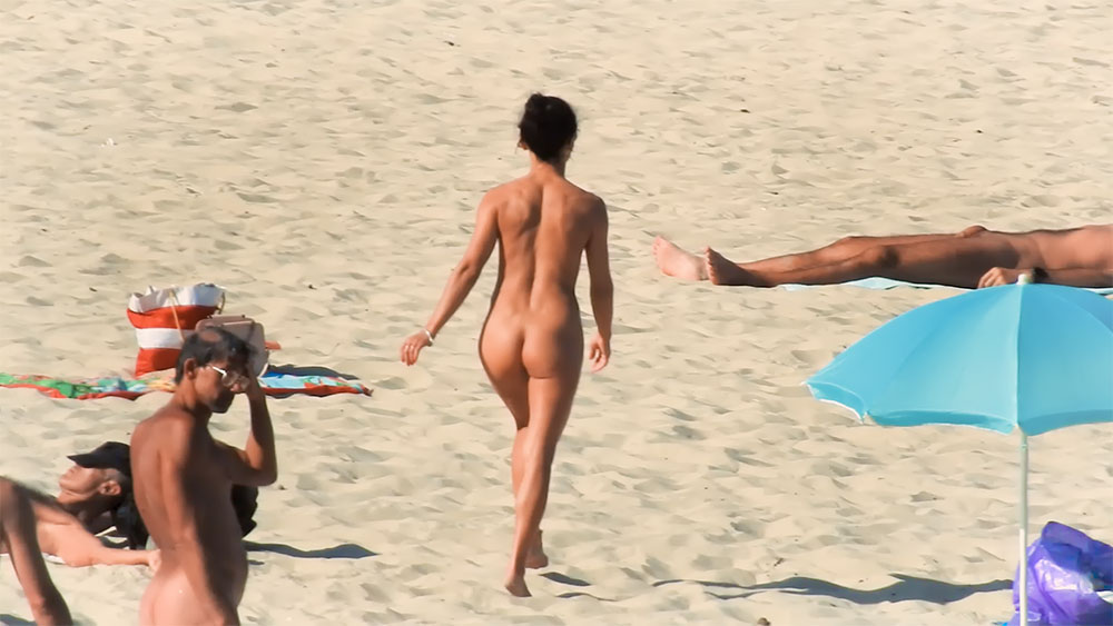 Nude Beach Stroll Past a Blue Inflatable Lounger