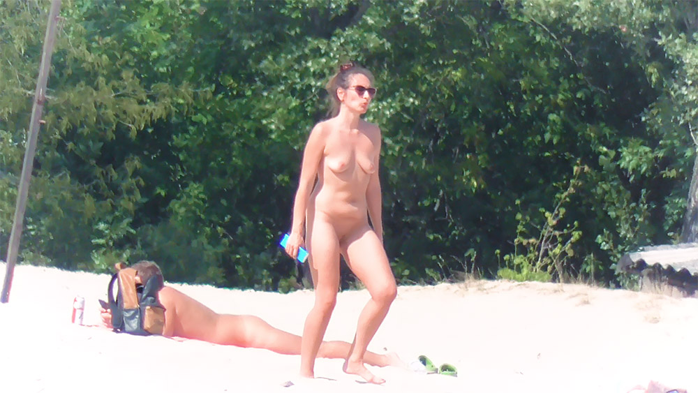 Stojąca na piasku plaży naturystów ze śladami po opalaniu