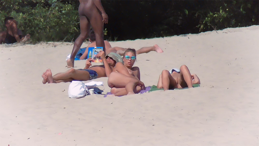 Three Women Topless on a Bright Sandy Beach