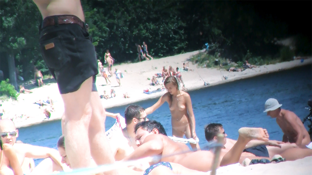 Vier naturisten liggen naast een zonovergoten zwembad
