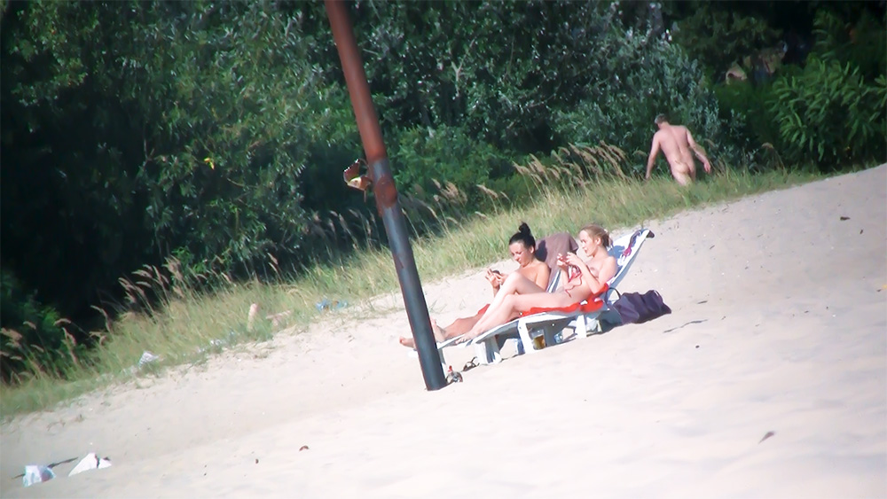 Striped Beach Loungers with Two Topless Sunbathers