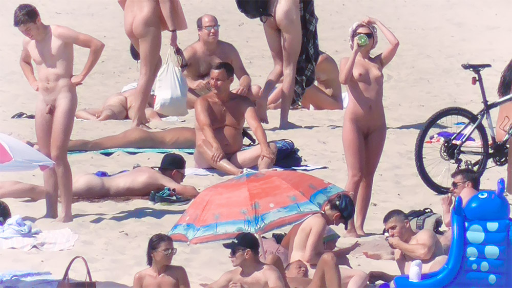 Momento en playa nudista junto a una bicicleta aparcada en la arena