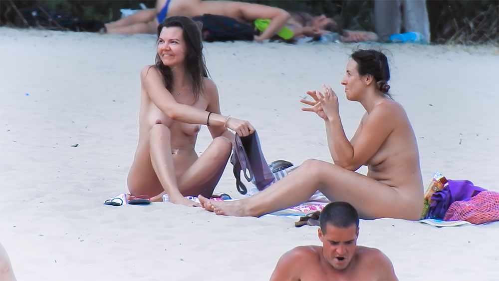 Three Nudists Sharing a Sunny Moment on the Sand