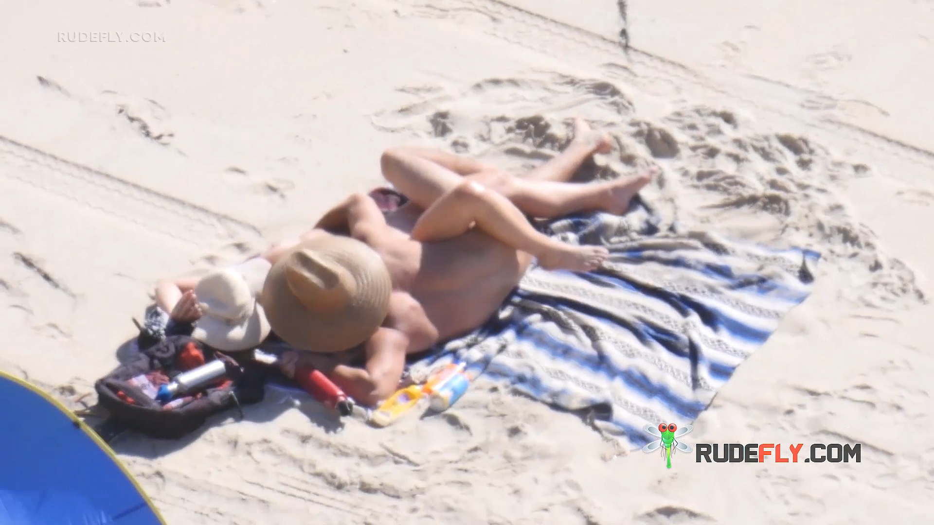 Nude Beach Couple on a Blue Striped Towel with Sun Hat