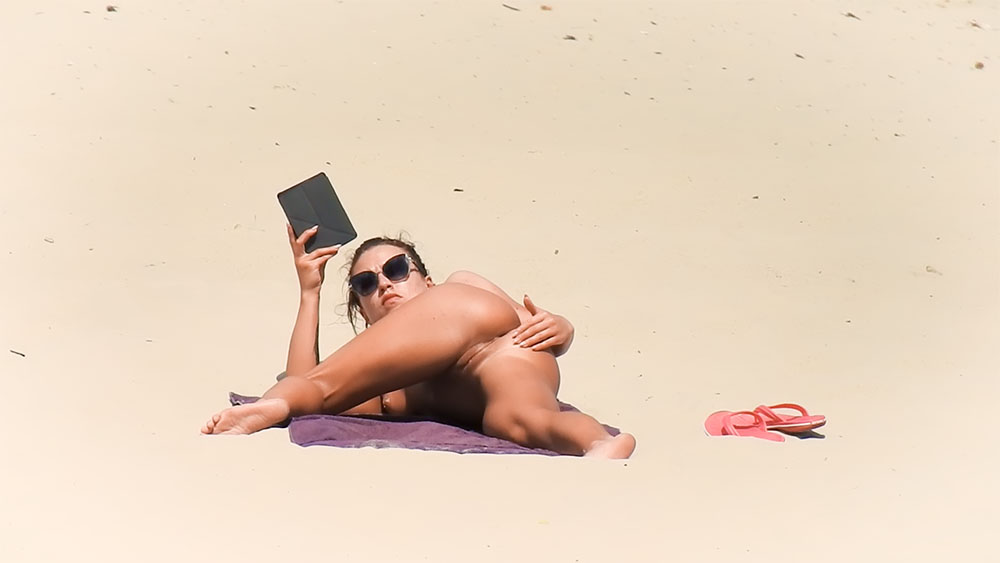 Grey Towel Nude Beach Lounging with Sunglasses and Tablet