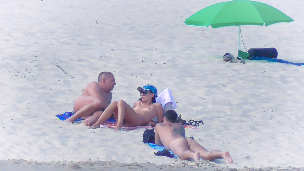 Tři nudisté sdílejí osušky na písku