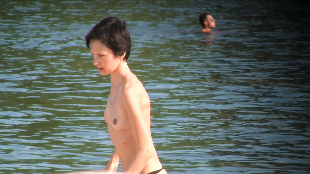 One Short-Haired Woman Topless in Calm Lake Water
