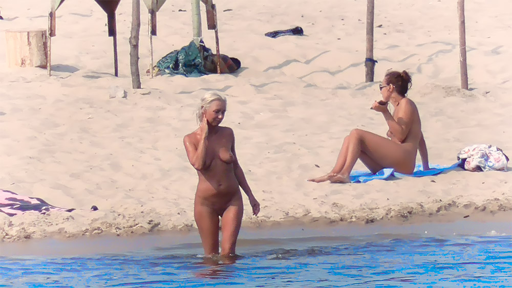 Two Nudists Sharing a Quiet Stretch of Shoreline