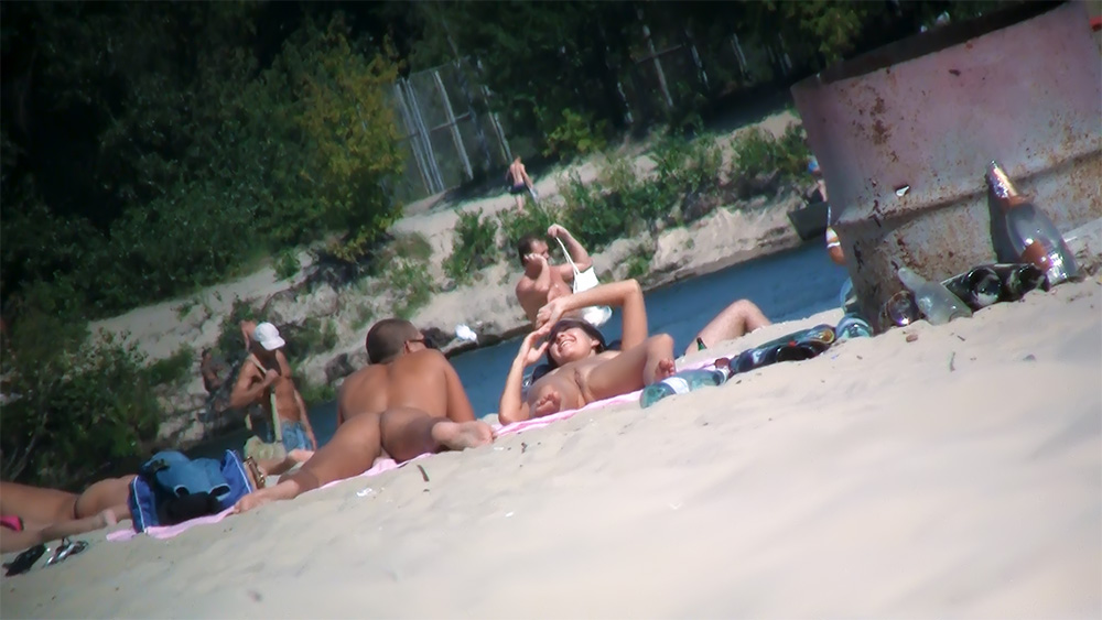 Five Naturists Resting on Towels by the River