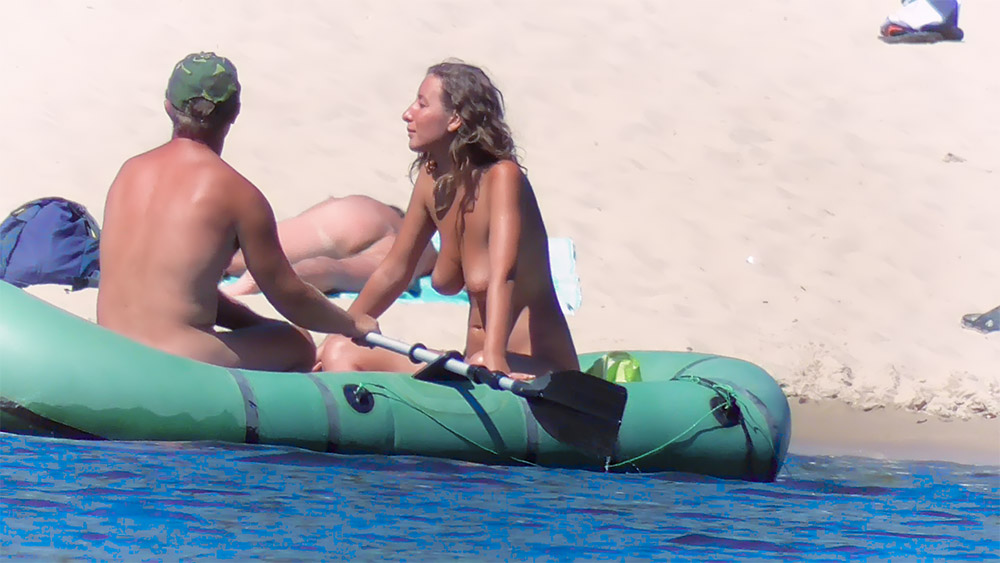Dos naturistas sentados en una balsa inflable