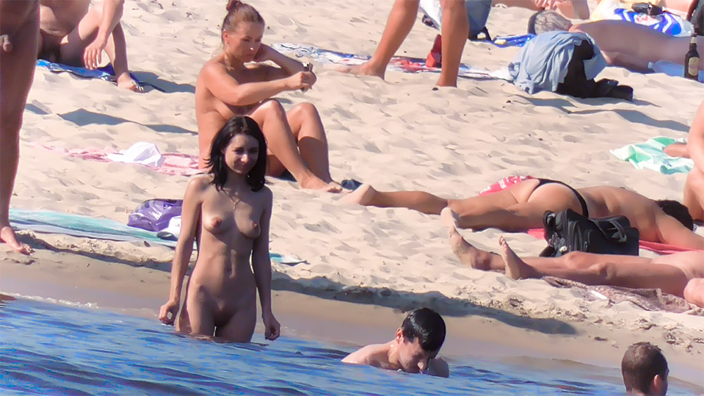 In piedi nell'acqua bassa in una spiaggia per nudisti