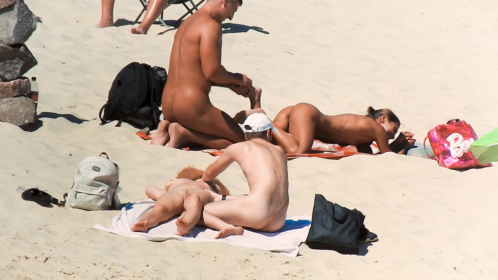 Pět nudistů pohromadě na jasných plážových ručnících